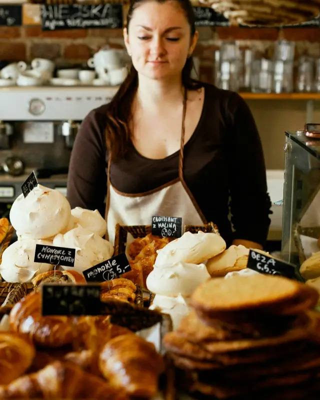 A baker behind a counter of fresh bread